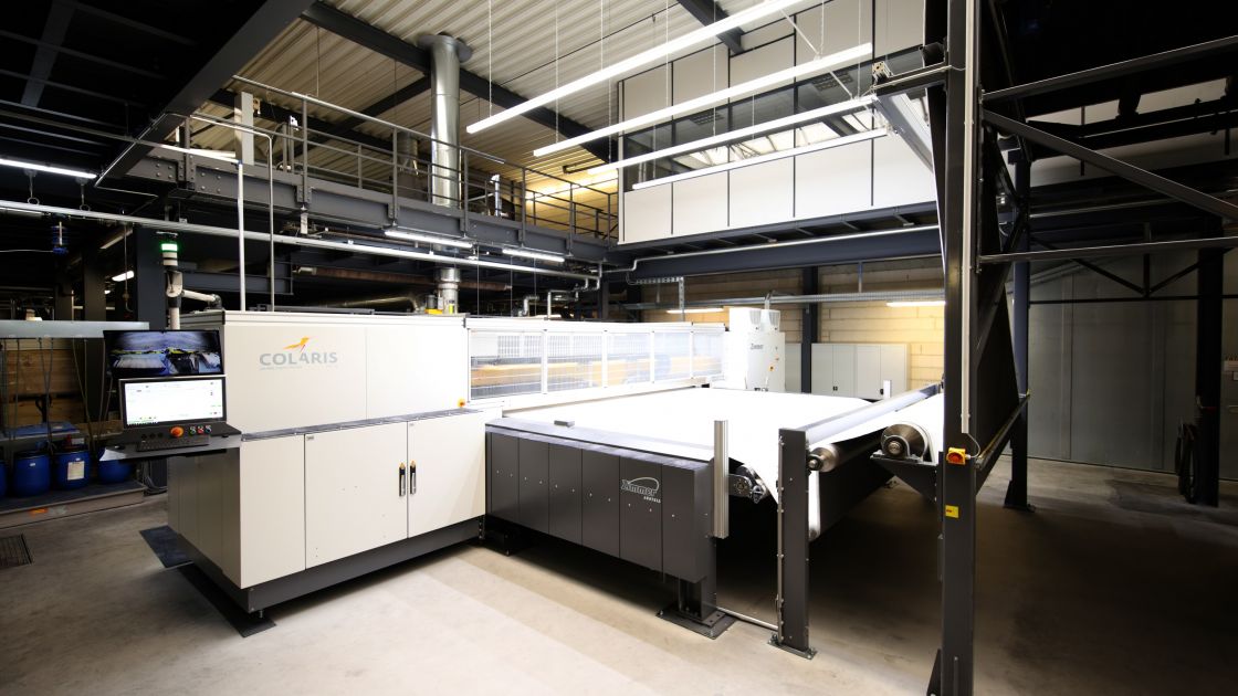 Blick auf den Druckkopf und Drucktisch der Teppichdruckanlage im Produktionsbetrieb Blick auf den Druckkopf und Drucktisch der Teppichdruckanlage im Produktionsbetrieb