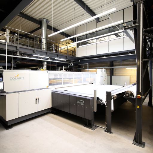 Blick auf den Druckkopf und Drucktisch der Teppichdruckanlage im Produktionsbetrieb Blick auf den Druckkopf und Drucktisch der Teppichdruckanlage im Produktionsbetrieb
